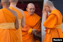 FILE - Phra Dhammachayo, center, arrives for a ceremony at the Dhammakaya Temple in Pathum Thani province, north of Bangkok, on Makha Bucha Day, March 4, 2015.