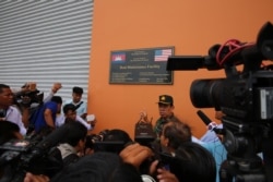 File - Chhum Socheat, spokesperson for Cambodia’s defense ministry, shows a group of invited journalists the U.S.-funded Boat Maintenance Facility building during a rare media tour at Ream Naval Base in Preah Sihanouk province, Friday, July 26, 2019. (Sophat Soeung/VOA Khmer)