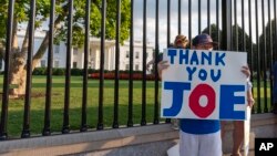 Hugh Kieve (10) iz Washingtona drži natpis ispred Bijele kuće, u nedjelju, 21. jula 2024, u Washingtonu.