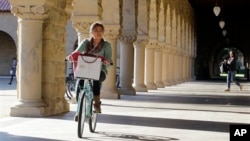 A Stanford University student bikes her way through the halls on the Stanford University campus in Palo Alto, Calif.