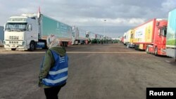 FILE PHOTO: Trucks carrying humanitarian aid from Egyptian NGOs for Palestinians, wait for the reopening of the Rafah crossing at the Egyptian side