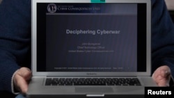 A cyber warfare expert who is chief technology officer of the U.S. Cyber Consequences Unit, a non-profit group that studies the impact of cyber threats, holds a notebook computer while posing for a portrait, (File photo).