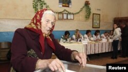 An elderly woman casts her vote at a polling station during the parliamentary elections in the village of Fiina, some 40 km (25 miles) north of Lviv October 28, 2012. Ukrainians voted on Sunday in an election that President Viktor Yanukovich's pro-busines