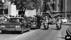 El convertible en primer plano en el que el presidente John F. Kennedy recibió un disparo mortal mientras la primera dama Jacqueline Kennedy sostiene su antebrazo en Dallas, el 1 de noviembre de 2019. 22, 1963.