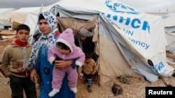 Syrian refugees leave their tents after heavy rain, Al-Zaatari refugee camp, Mafraq, Jordan, Jan. 8, 2013.