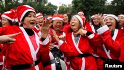 In Hanoi, members of the Laughter Yoga wear Santa Claus costumes during a morning exercise in a public park, December 23, 2012. (Reuters Photo)