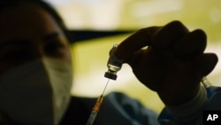 Un trabajador de la salud prepara una dosis de la vacuna Sinopharm en un centro de vacunación instalado en el estacionamiento del Instituto de Previsión Social de las Fuerzas Armadas (IPSFA) en Caracas, el 7 de junio de 2021.