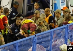 Firefighters carry an injured person on a stretcher during Carnival celebrations at the Sambadrome in Rio de Janeiro, Brazil, Feb. 26, 2017.
