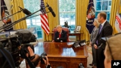 President Donald Trump speaks to media as he meets with Homeland Security Secretary Kirstjen Nielsen and FEMA Administrator Brock Long, right, to discuss Hurricane Michael, at the White House in Washington, Wednesday, Oct. 10, 2018. (AP Photo/Pablo Martinez Monsivais)
