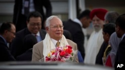 Malaysian Prime Minister Najib Razak holds a bouquet of flowers presented to him upon arrival in New Delhi, India, March 31, 2017.
