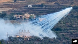 En esta imagen de archivo, un proyectil que parece ser de fósforo blanco de la artillería israelí explora sobre una vivienda en al-Bustan, una localidad libanesa en la frontera con Israel, el 15 de octubre de 2023. 