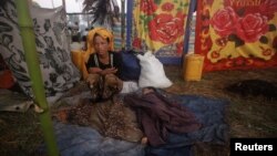 A woman displaced by the recent violence in Pauktaw sits by her sleeping child at Owntaw refugee camp for Muslims outside Sittwe, Burma, November 1, 2012.