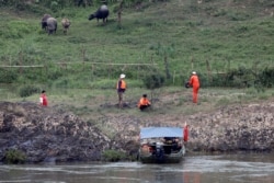 FILE - A Chinese team of geologists surveys the Mekong River banks, at the Laos side, at the border between Laos and Thailand, April 23, 2017.