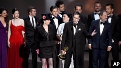 Amy Sherman-Palladino, front and center left, Daniel Palladino and the cast and crew of "The Marvelous Mrs. Maisel" accept the award for outstanding comedy series at the 70th Primetime Emmy Awards, Sept. 17, 2018, at the Microsoft Theater in Los Angeles.