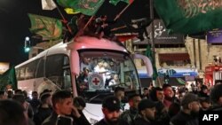 Una multitud rodea a un autobús de la Cruz Roja con prisioneros palestinos liberados por Israel en Ramalah, Cisjordania, el 26 de noviembre de 2023.