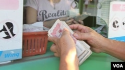 រូបឯកសារ៖ ពលរដ្ឋ​ខ្មែរ​រាប់​លុយ​រៀល ដែល​ជា​រូបិយប័ណ្ណ​ជាតិ នៅ​ឯ​តូប​ដូរ​លុយ​ក្នុង​ស្រុក​មួយ​នៅ​រាជធានី​ភ្នំពេញ នៅ​ថ្ងៃ​ទី៧ ខែ​មេសា ឆ្នាំ២០១៦។ (វីអូអេ)