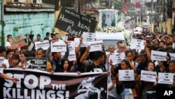 ក្រុម​បាតុករ និង​អ្នក​គាំទ្រ​កាន់​បដា​ និង​ប័ណ្ណ​នានា នៅ​ពេល​ពួកគេ​ដើរ​ក្បួន​ជាមួយ​នឹង​រថយន្ត​ដឹក​សព​លោក Kian Loyd delos Santos ដែល​ជា​និស្សិត​អាយុ​១៧ឆ្នាំ ក្នុង​ពិធីបុណ្យ​សព​របស់​លោក កាលពី​ថ្ងៃទី២៦ ខែសីហា​ ឆ្នាំ២០១៧។