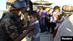 Iordaniyalik askar suriyalik qochqinlarga yordam bermoqda.