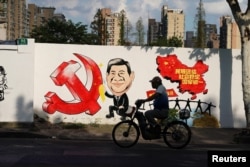 2018年9月28日，上海一条街上的宣传画，包括习近平的漫画形象、中共党徽和中国地图，还有文字“民族团结，社会稳定，国家统一”