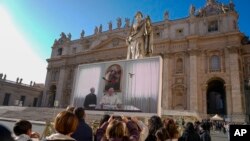 Paus Fransiskus muncul pada layar besar yang terpasang di Lapangan Santo Petrus, pada 3 Desember 2023. (Foto: AP/Andrew Medichini)