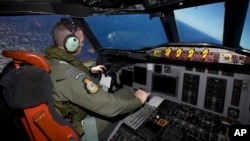 Captain Flt. Lt. Tim McAlevey of the Royal New Zealand Air Force flies a P-3 Orion in search for the missing Malaysia Airlines Flight 370 over the Indian Ocean, April 11, 2014.