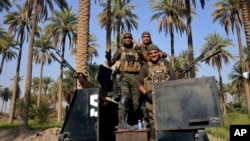 FILE - Iraqi security forces patrol Jurf al-Sakhar, 70 kilometers south of Baghdad, Oct. 25, 2014.