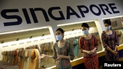 Cabin crew speak to participants during a guided tour at the Singapore Airlines Training Centre in Singapore November 21, 2020.
