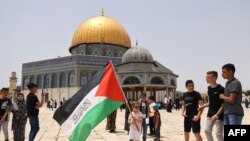Waumini wa Kiislam wa Palestina wakusanyika kufanya ibada katika uwanja wa msikiti wa al-Aqsa, eneo la tatu kwa utukufu katika dini ya Kiislam, Mei 21,2021.(Photo by AHMAD GHARABLI / AFP)