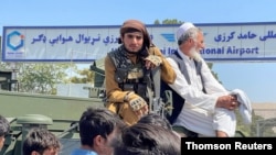 Un miembro de las fuerzas del Talibán viaja en un vehículo blindado fuera del Aeropuerto Internacional Hamid Karzai en Kabul, el lunes 16 de agosto de 2021.
