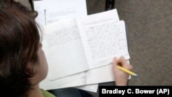 FILE - Student Elise Harry works on a writing assignment on March 29, 2005, at the Exton, Pennsylvania campus of Delaware County Community College.