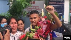 យុវជន កាក់ សុវណ្ណច្ឆ័យ អាយុ​១៦ឆ្នាំ លើក​ដៃ​ឆ្វេង ក្រោយ​ត្រូវបាន​ដោះលែង​ពី​ពន្ធនាគារ នៅ​ថ្ងៃទី១០ ខែវិច្ឆិកា ឆ្នាំ២០២១។ (មាស មល្លិកា/វីអូអេ)