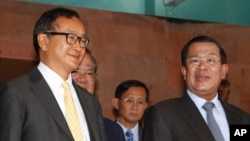 FILE PHOTO - Cambodian Prime Minister Hun Sen, right, talks with the main Opposition Party leader Sam Rainsy, left, of Cambodia National Rescue Party, after their meeting in Senate headquarters in Phnom Penh, Cambodia, Tuesday, July 22, 2012.