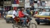 Un moto-taxi passe devant le marché Mokolo à Yaoundé, Cameroun, le 11 octobre 2018. (AP Photo/Sunday Alamba)