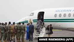 Les chefs militaires maliens saluent l'ancien président nigérian Goodluck Jonathan à son arrivée à l'aéroport de Bamako avant une rencontre entre les chefs militaires maliens et une délégation de la CEDEAO qu'il dirige le 22 août 2020.
