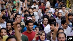 Supporters of the Iranian presidential candidate Hasan Rowhani, shown in poster at center, attend a celebration gathering in Tehran, Iran, June 15, 2013.