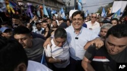 El candidato presidencial Carlos Pineda (centro) del partido Prosperidad Ciudadana sale de la Corte Constitucional en la Ciudad de Guatemala, el sábado 20 de mayo de 2023. Pineda busca revertir una decisión judicial que lo excluyó del proceso electoral. (Foto AP/Moisés Castillo)