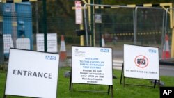 Signs offer directions outside a COVID-19 drive through test center in Bidston, England, Oct. 12, 2020.