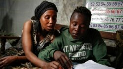 FILE - In this Saturday, Sept. 26, 2020 file photo, Miriam Nyambura helps her son Peter Kihika, 16, who wants to become a teacher.