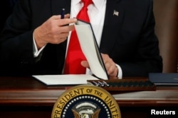 US President Donald Trump prepares to sign an executive order at Homeland Security headquarters in Washington, Jan. 25, 2017.