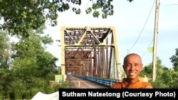 Buddhist monk Sutham Nateetong is taking a picture on rout 66 during his walking trip across the US to promote peace.