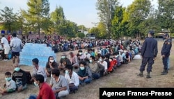 FILE - This photo taken Dec. 16, 2021, by Metta Charity shows people from Myanmar who fled a surge in violence, sitting in lines as they are processed in Mae Tao Phae, in Thailand's Mae Sot district.
