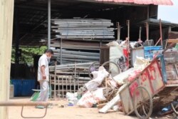 Mao Tran surveys piles of scraps stored at a rented warehouse in Phnom Penh, Cambodia, April 22, 2020. (Phorn Bopha/VOA Khmer)