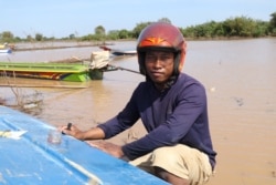 លោក លន លី អាយុ​២៥ឆ្នាំ ដែល​ជា​កសិករ​ធ្វើ​ស្រែ​ម្នាក់​ក្នុង​ឃុំ​ច្រណូក ស្រុក​កំពង់លែង ខេត្ត​កំពង់ឆ្នាំង ជួសជុល​ទូក​របស់​លោក ដោយសារ​វា​បែក កាលពី​ថ្ងៃទី១១ ខែធ្នូ ឆ្នាំ២០២១។ (ស៊ុន ណារិន/វីអូអេ)