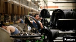 中國河北邢台萬達輪胎公司的工人正在生產出口美日的汽車輪胎生產線上工作。 （2019年5月21日）