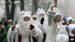 People dressed as Father Frost, the named used locally for Santa Claus, and Snow Maiden greet passers-by during a New Year parade in Bishkek, Kyrgyzstan. (Reuters Image)