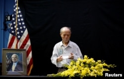 Vietnamese veteran Pham Minh Chuc, 81, pays respect after he wrote in a condolence book near a portrait of U.S. Senator John McCain (R-AZ) at the U.S. embassy in Hanoi, Vietnam, Aug. 27, 2018.