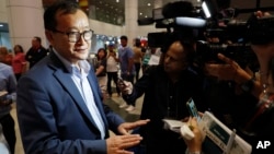 Cambodia's exiled opposition leader Sam Rainsy, left, speaks to the media as he arrived at Kuala Lumpur International's Airport in Sepang, Malaysia Saturday, Nov. 9, 2019. 