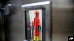 FILE - In this March 19, 2020, file photo, a biosafety protective suit for handling viral diseases are hung up in a biosafety level 4 training facility at U.S. Army Medical Research and Development Command at Fort Detrick in Frederick, Md. (AP Photo/Andr