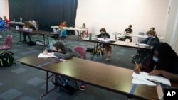 Students from Hesston Middle School hold class at the Cross Winds Convention Center in Hesston, Kan., Friday, Nov. 6, 2020. (AP Photo/Orlin Wagner)