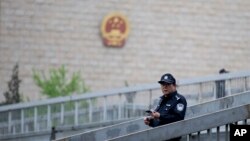 資料照：一名警察在北京審理維權律師許志永案的中國最高人民法院外巡邏。 （2014年4月11日）